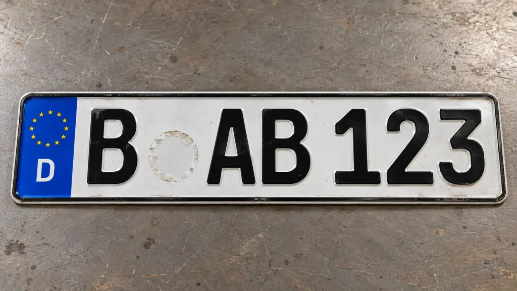 Abgenommenes Kennzeichenschild mit sichtbarer Stelle der entfernten Stempelplakette nach einer Fahrzeugabmeldung